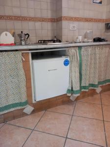 una cucina con lavastoviglie sotto un bancone con tende di Anny house a Napoli