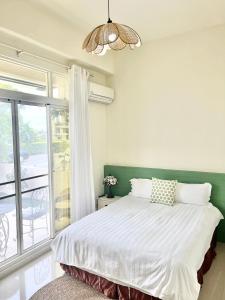a bedroom with a bed and a large window at 永安101 Wing on x 附陽台 in Taitung City