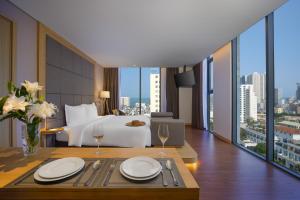 a hotel room with a bed and a table with wine glasses at Estrella Boutique Hotel in Da Nang