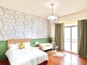 台東市的住宿－永安101 Wing on，一间卧室设有一张床和绿色的墙壁
