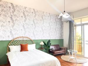 a bedroom with a white bed and a green wall at 永安101 Wing on x 附陽台 in Taitung City