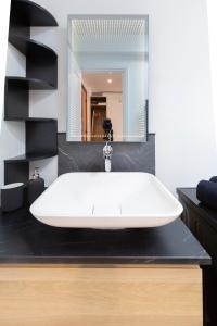 a bathroom with a white sink and a mirror at EDOUARD VII - STUDIO - Carré d'or Menton in Menton +9 photos