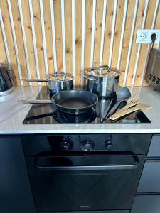 a stove with pots and pans on top of it at Luxusný apartmán na 21 poschodí s parkovaním zadarmo BA in Bratislava