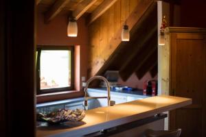 eine Küche mit einer Theke, einem Waschbecken und einem Fenster in der Unterkunft Lodjadis in Labaroche