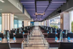 a row of tables and chairs in a room with windows at Melia Alicante in Alicante +37 photos