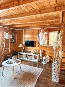 a living room with a table and a tv at KaSper River House in Ledine