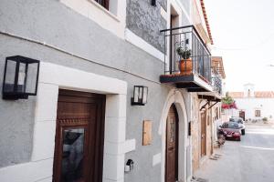 a building with a door and a balcony with a plant on it at Achilleas cozy house in Prinés