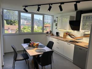 uma cozinha com uma mesa e cadeiras numa cozinha em Apartment Toni em Lovran