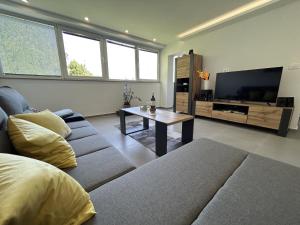 een woonkamer met een bank en een tv bij Apartment Toni in Lovran