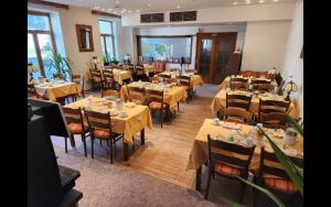 een eetkamer met tafels en stoelen met geel tafelkleed bij Hotel Lava Vulkaneifel in Daun