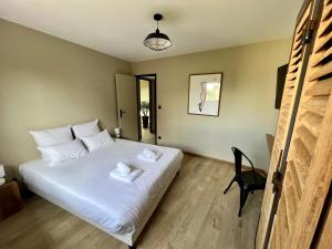 a bedroom with a white bed with a black chair at Le Loft Manhattan, en centre ville, proche Sainte Bernadette avec Parking, PRIMO C0NCIERGERIE in Nevers +16 photos
