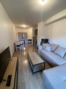 a living room with a couch and a table at Appartement très cosy en plein centre in Les Gets