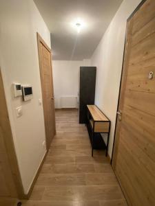 a hallway with a door and a table and a refrigerator at Appartement très cosy en plein centre in Les Gets