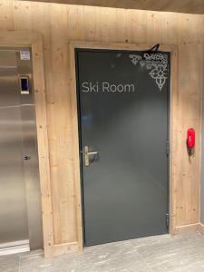 a door to a ski room with a sign on it at Appartement très cosy en plein centre in Les Gets