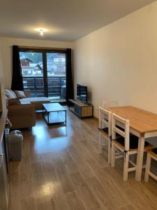 a living room with a table and a couch at Appartement très cosy en plein centre in Les Gets