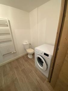 a washing machine in a bathroom with a toilet at Appartement très cosy en plein centre in Les Gets