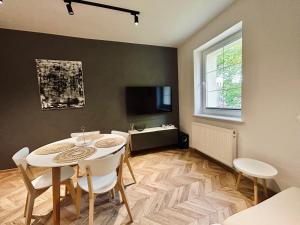 a dining room with a white table and chairs at Apartament Centrum A in Wejherowo