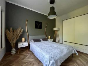 a bedroom with a bed with a blue comforter at Apartament Centrum A in Wejherowo