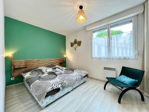 een slaapkamer met een bed, een stoel en een raam bij COC - La Belle Etoile in Wissant