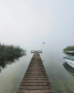 a dock in the middle of the water with a boat at Nasze Calle in Węgorzewo