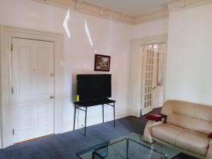 sala de estar con sofá y TV de pantalla plana en Mini Mansion Hotel affordable stays Plainfield NJ near public transportation, en Plainfield