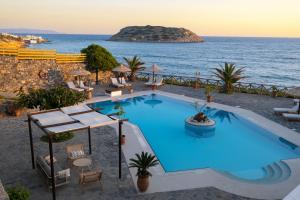a swimming pool with the ocean in the background at Mochlos Blue in Mochlos