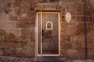 uma porta do lado de um edifício de tijolos em Anadolu Evleri em Gaziantep