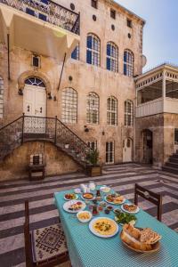 einen Tisch mit Teller mit Lebensmitteln auf einem Gebäude in der Unterkunft Anadolu Evleri in Gaziantep