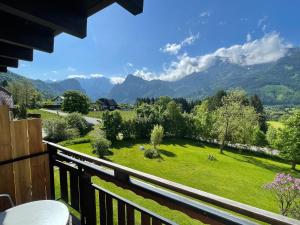 a balcony with a view of a field and mountains at Berghaus Gesäuse Pension in Weng im Gesäuse