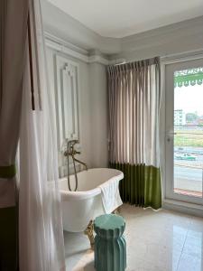 Wiang Ville Boutique Hotel في شيانغ ماي: حمام مع حوض استحمام و نافذة كبيرة