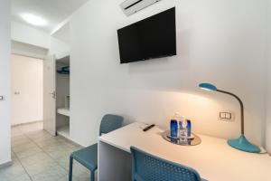 Pokój ze stołem z krzesłami i telewizorem na ścianie w obiekcie B&B il Rifugio w mieście Carbonia