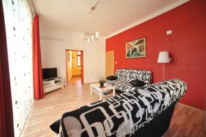 Apartma Most في موست نا سوتشي: غرفة معيشة مع أريكة وجدار احمر