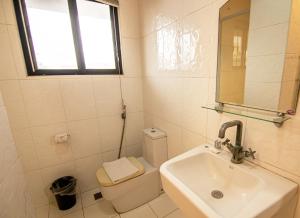 a bathroom with a sink and a toilet and a window at Kiwi Hotel in Cebu City