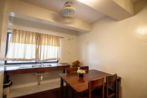 a kitchen with a table and a sink and a window at Kiwi Hotel in Cebu City