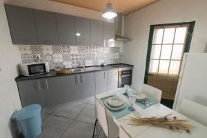 a kitchen with a table with chairs and a microwave at Casa da Avó in Alcácer do Sal