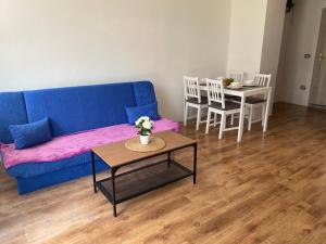 sala de estar con sofá azul y mesa en Apartmani Mateja2, en Koper