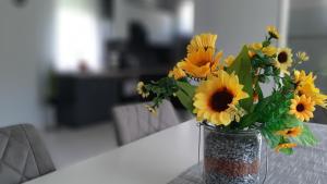 wazę wypełnioną słonecznikami siedzącą na stole w obiekcie Jenny vendégház w Zalakaros