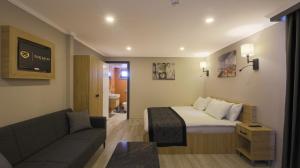 Habitación de hotel con cama y sofá en Side Leon Otel en Side