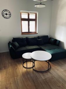 a living room with a green couch and a white table at Apartmány 400 in Veľká Lomnica
