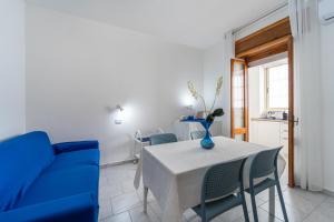 a dining room with a table and a blue couch at B&B il Rifugio in Carbonia