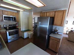 La cuisine est équipée d'un réfrigérateur en acier inoxydable et de placards en bois. dans l'établissement Rr-edgewater13, à June Lake