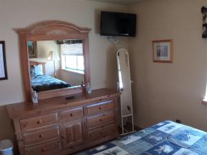 una camera con cassettiera, specchio e letto di Rr-edgewater13 a June Lake