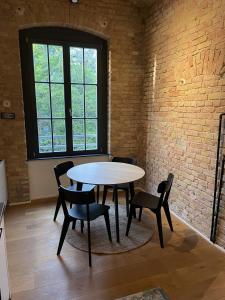 a table and chairs in a room with a brick wall at Stylisches Loft mitten in Berlin in Berlin