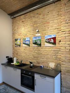 a kitchen with a brick wall with signs on it at Stylisches Loft mitten in Berlin in Berlin +2 photos