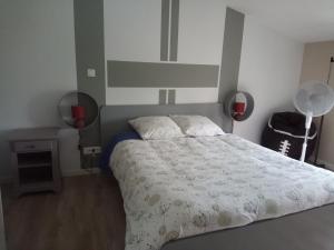 1 dormitorio con 1 cama con edredón blanco en Chambre d'hôtes 84 de la Manelière, en La Flocellière