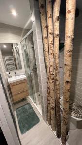 ein Bad mit einer Dusche mit gefälschten Bäumen in der Unterkunft Chambre d hôte petit crussac in Mauvezin