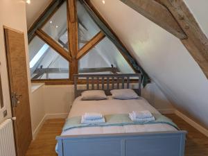 uma cama num quarto com uma grande janela em La Grange de la Porterie - Magnificent House and Barn Conversion in Historic village em Chapaize