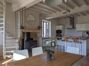 uma cozinha e sala de estar com mesa e cadeiras em La Grange de la Porterie - Magnificent House and Barn Conversion in Historic village em Chapaize