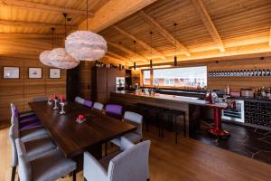 una sala da pranzo con tavolo, sedie e bar di Riffelalp Lodge a Sankt Anton am Arlberg