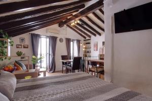 a bedroom with a bed and a living room at The Nook (El Recoveco) in Canillas de Aceituno